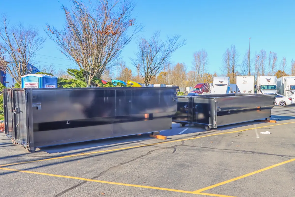 Professional dumpster rental service with roll-off container on residential driveway in Opelika